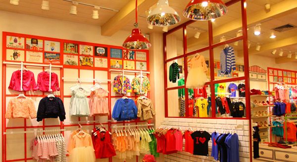 Shop quần áo trẻ em với kệ treo sản phẩm hình lưới chữ nhật và các hình trang trí nghộ nghĩnh