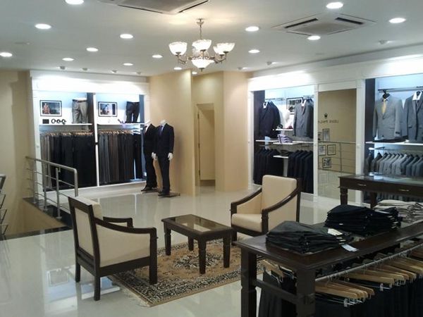 Mẫu cửa hàng quần áo nam với bàn ghế cho khách hàng ngồi trải nghiệm sản phẩm